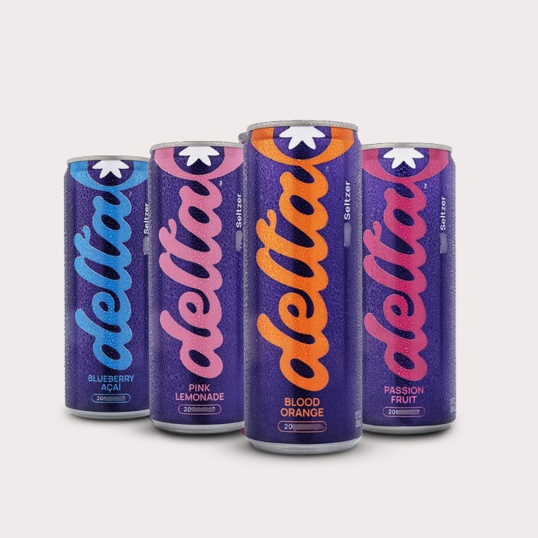 Delta Bold cans in a warm-lit room, lamp on, the slow part of the evening